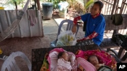 Kheang Pichphanith, 24, who is among those relocated from Cambodia's archaeological site, sits next to her 1-month-old twin babies at her home in Run Ta Ek village in Siem Reap province, Cambodia, April 2, 2024. 