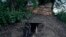 FILE - An armed tribal Kuki walks out of an underground bunker at a de facto front line dissecting two ethnic zones in Churachandpur, in the Indian state of Manipur, June 20, 2023.