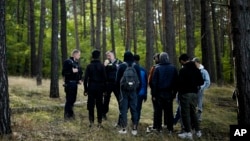 FILE - Federal Police attempt to find a group of migrants who illegally crossed the border from Poland into Germany, while on patrol in a forest near Forst south east of Berlin, Germany, on Oct. 11, 2023. (AP Photo/Markus Schreiber, File)