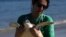 FILE - A volunteer carries a Green Sea Turtle after it was caught temporarily at a feeding site on Itaipu Beach in Niteroi, Brazil, May 24, 2023. Nearly half of the world's migratory species are in decline, according to a new UN report, Feb. 12, 2024.