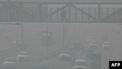 Commuters make their way along a road amid heavy smoggy conditions in New Delhi, Nov. 5, 2023. 