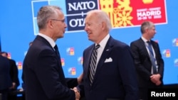 Jens Stoltenberg i Joe Biden se rukuju.