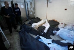 Palestinians look at the bodies of relatives killed in the Israeli bombardment of the Gaza Strip, inside a morgue of Al Aqsa hospital, in Deir al Balah, Gaza Strip, Feb. 6, 2024.