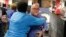 FILE - Charlotte Observer editorial cartoonist Kevin Siers, right, gets a hug from a co-worker as they celebrate Siers winning the Pulitzer Prize for Editorial Cartooning at the newspaper in Charlotte, North Carolina, April 14, 2014. Siers was among cartoonists laid off last week