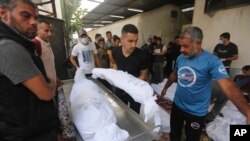 Palestinians carry the bodies of their relatives killed in the Israeli bombardment of the Gaza Strip outside a morgue in Rafah, Oct 25, 2023.