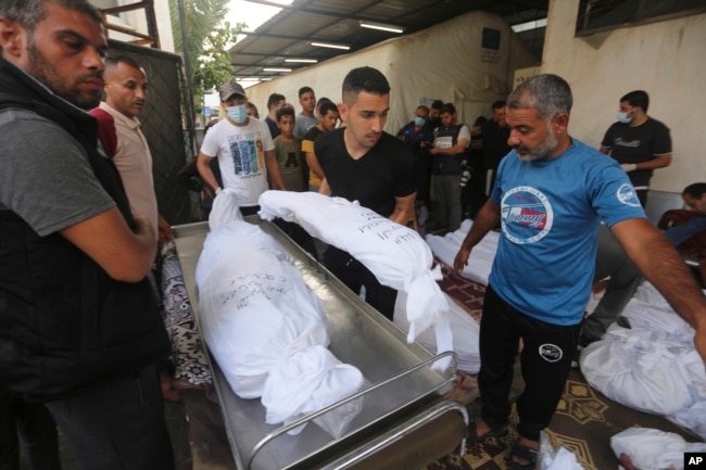 Palestinians carry the bodies of their relatives killed in the Israeli bombardment of the Gaza Strip outside a morgue in Rafah, Oct 25, 2023.