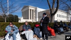 Gente hace fila frente a la Corte Suprema de EEUU para poder asistir a la audiencia que decidirá si el expresidente Donald Trump está inhabilitado para presentarse como candidato en 2024, 7 de febrero de 2024, en Washington. 