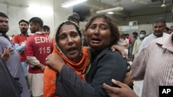 Warga berkumpul di sebuah kamar jenazah di Karachi, Pakistan, tampak berduka karena kehilangan anggota keluarga yang tewas dalam insiden desak-desakan di pusat distribusi bantuan makanan selama bulan suci Ramadan, Jumat 31 Maret 2023.