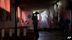 FILE - A health worker holds a toddler at the Fontaine Hospital Center that treats malnourished children in the Cite Soleil area of Port-au-Prince, Haiti, May 29, 2023.