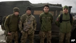 FILE - Colombian veterans who joined the Ukrainian armed forces to help fight Russia pose for a photo near their Humvee on the front line near Lyman, Donetsk region, Ukraine, Jan. 29, 2024. 