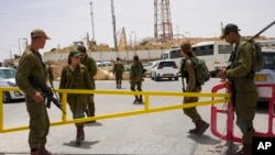 Israeli soldiers secure a gate leading to a military base following a deadly shootout in southern Israel along the Egyptian border, June 3, 2023.