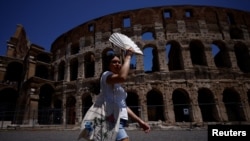 A tourist uses a fan to shelter from the sun near the Colosseum during a heatwave in Rome, July 11, 2023. The beginning of July was Earth's hottest week on record, according to early findings on July 10 from the World Meteorological Organization.