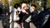 一名男子背着一个女孩离开北京的一所儿童医院。(2023年11月24日)
