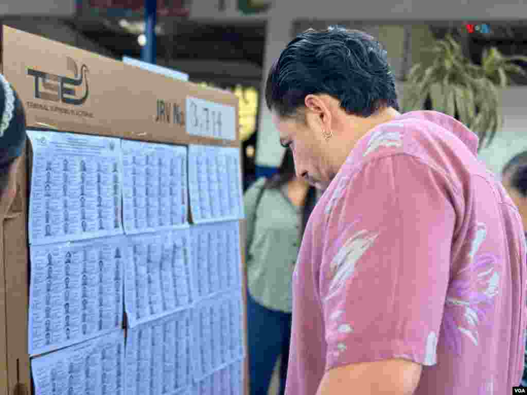 Votante examina listas en el centro de votación en Quezaltepeque, La Libertad, El Salvador.