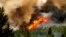 FILE - Flames from the Donnie Creek wildfire burn along a ridge top north of Fort St. John, British Columbia, Canada, July 2, 2023. 