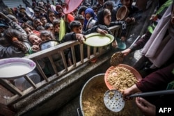 FILE—Displaced Palestinian children gather to receive food at a government school in Rafah in the southern Gaza Strip on February 19, 2024.