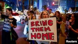 A woman holds a sign during a demonstration by family members and supporters of hostages who are being held in Gaza by Hamas gunmen, in Tel Aviv, Israel, Oct. 28, 2023.