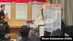 Petugas KPPSLN memastikan keabsahan suara pada surat suara pemilihan legislatif di harapan para saksi. (Foto: VOA/Rivan Dwiastono)