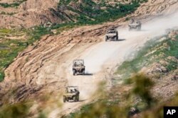 Israeli soldiers drive in the Gaza Strip, as seen from southern Israel, Feb. 4, 2024.