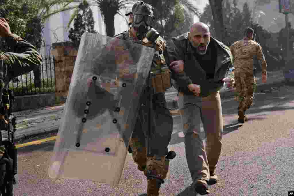 A Lebanese soldier helps his retired comrade after breathing in tear gas during a protest demanding better pay in Beirut.