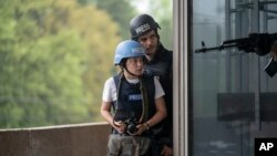 This image released by A24 shows Cailee Spaeny, left, and Wagner Moura in a scene from "Civil War." (Murray Close/A24 via AP)