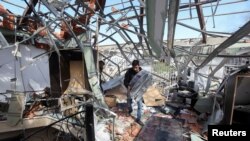 A man salvages items at a damaged site that was hit by an airstrike on Monday, after what Lebanon's state media said was a series of Israeli strikes around Ghaziyeh on Lebanon's coast around 60 km north of the border with Israel, Feb. 20, 2024