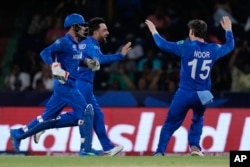 Afghanistan's captain Rashid Khan, center, celebrates the wicket of Australia's Matthew Wade during the men's T20 World Cup cricket match between Afghanistan and Australia at Arnos Vale Ground, Kingstown, Saint Vincent and the Grenadines, June 22, 2024.