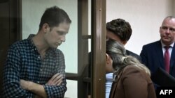 Nhà báo Mỹ phải đứng trong "tủ kính" dành cho bị cáo tại một tòa án ở Moscow, 18/4/2023.