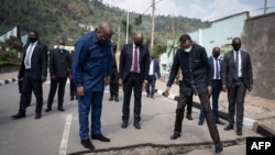 Mokonzi ya Rwand Paul Kagame (C-D) na mokonzi ya RDC Félix Tshisekedi (C-G) bazali kotala libulu lisalami nsima na botombokia ya volcan na nzela ya Rubavu, Rwanda, 25 sanza ya sambo 2021.