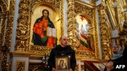 FILE - Worshippers wait to be blessed during the celebration of the Orthodox Easter at the Dormition Cathedral in the medieval cave monastery of Kyiv-Pechersk Lavra in Kyiv, Ukraine, on April 16, 2023.