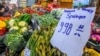 FILE - A cardboard displays the price of asparagus at the Bosnyak Market Hall in Budapest, Hungary, June 1, 2023. At 24.5 percent in April, inflation in Hungary was three times the EU average of 8.1 percent, with energy and food price inflation at 42 and 38 percent respectively.
