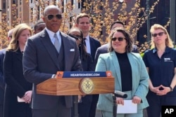 New York Mayor Eric Adams, left, introduces Kathleen Corradi, center, as the city's first-ever citywide director of rodent mitigation, also known as the "rat czar," in New York, Wednesday, April 12, 2023.