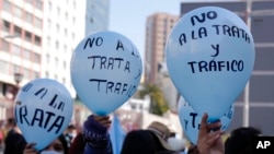 FILE - Students hold balloons that read in Spanish, "No to human trafficking," during a protest marking World Day Against Trafficking in Persons, in La Paz, Bolivia, July 29, 2022.