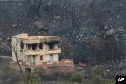 A view of a burnt house and forests, in Bouira, 100 km from Algiers, Algeria, Monday, July 24, 2023.