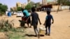 FILE - Children carry a bucket of water during clashes between the paramilitary Rapid Support Forces and the army in Khartoum North, Sudan, April 22, 2023.