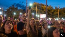 People use the lights on their mobile phones during a protest in Belgrade, Serbia, July 1, 2023.