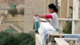 ဂျော်ဒန်နိုင်ငံ Amman မြို့က အိမ်ရှင်နေအိမ်ရဲ့ ဝရန်တာမှာ အဝတ်လှန်းနေတဲ့ ဖိလစ်ပိုင် အိမ်အကူအမျိုးသမီးတဦး (ဒီဇင်ဘာ ၂၀၊ ၂၀၀၈)