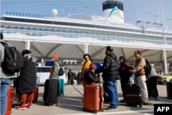 Los pasajeros hacen cola para abordar el primer crucero construido en China, el Adora Magic City, en Shanghai, el 1 de enero de 2024.