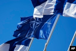 A NATO and Finnish flags flutter near the building of the Ministry of Internal Affairs in Helsinki, Finland, April 4, 2023.