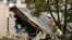 A man views damage to a building caused by recent flooding, Sept. 13, 2023, at the Hilton & Cook Marketplace in Leominster, Mass.