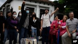 People gather outside the Constitutional Court where a session to examine the complaints of several political parties about irregularities in the June 25 general elections is underway in Guatemala City, July 1, 2023. 