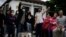 People gather outside the Constitutional Court where a session to examine the complaints of several political parties about irregularities in the June 25 general elections is underway in Guatemala City, July 1, 2023. 