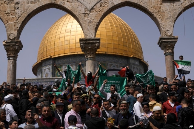 FILE - Palestinians hold the Palestinian national flag and the flag of the Hamas militant group during a protest by the Dome of Rock at the Al-Aqsa Mosque compound in the Old City of Jerusalem on April 7, 2023. (AP Photo/Mahmoud Illean)