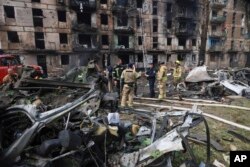 Emergency workers inspect a damaged multi-story apartment building caused by the latest rocket Russian attack in Kryvyi Rih, Ukraine, June 13, 2023.