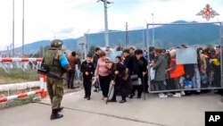 Seorang penjaga perdamaian Rusia menjaga gerbang kamp dekat Stepanakert di Nagorno-Karabakh, Dalam gambar yang diambil dari video yang dirilis oleh Layanan Pers Kementerian Pertahanan Rusia, Kamis, 21 September 2023. (Layanan Pers Kementerian Pertahanan Rusia via AP)