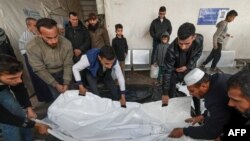 Palestinians mourn over the body of a victim following Israeli bombardment on Rafah in the southern Gaza Strip, at al-Najar hospital on Friday February 16, 2024, amid ongoing battles between Israel and the Palestinian militant group, Hamas.