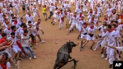 Revelers stand the bull ring at the end of the fourth running of the bulls during the San Fermin fiestas in Pamplona, Spain.