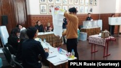 Pemilih membuka surat suara, memastikan masih kosong dan tidak rusak sebelum mencoblos di TPS Luar Negeri di Moskow. (Foto: Courtesy/PPLN Rusia)