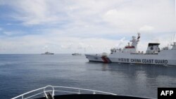 Kapal-kapal garda pantai China menghalangi kapal Dinas Perikanan dan Sumber Daya Perairan Filipina saat kapal itu berlayar dekat jalan masuk ke Scarborough Shoal yang dikuasai China di Laut China Selatan yang disengketakan, 22 September 2023. (Foto: (Photo: Ted Aljibe / AFP)