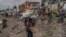 Un jeune garçon porte quelques-uns de ses biens alors que les gens fuient le territoire de Masisi suite aux affrontements entre les rebelles du M23 et les forces gouvernementales, sur une route près de Sake le 7 février 2024. (Photo par Aubin Mukoni / AFP)